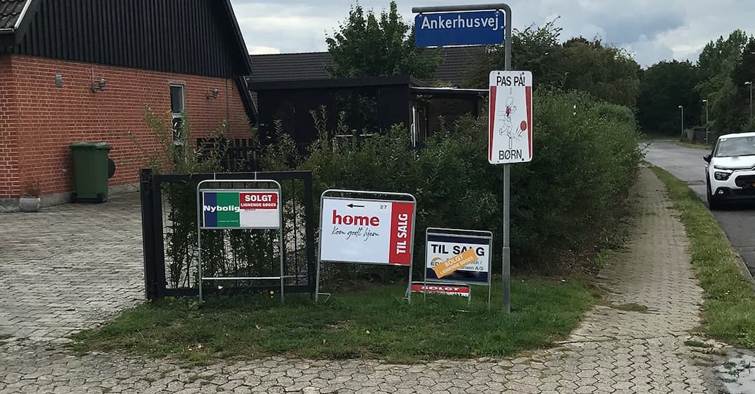 Residential street corner with sale signs, a 